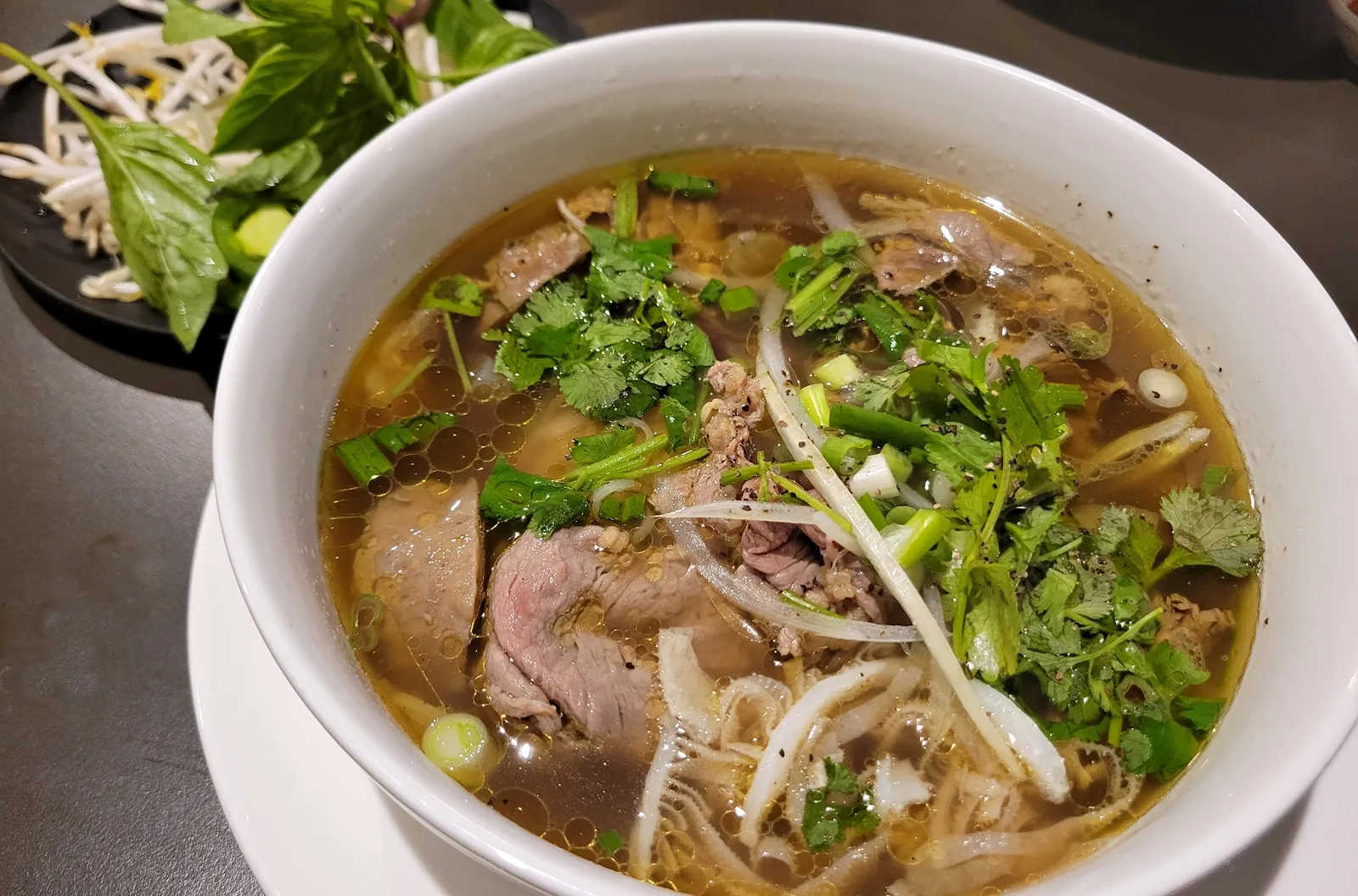 Combination pho with beef, herbs, onions, and rich broth